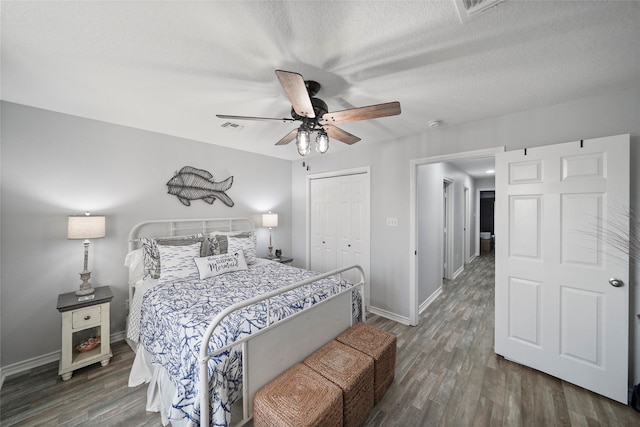 bedroom featuring a textured ceiling, dark wood-type flooring, ceiling fan, and a closet