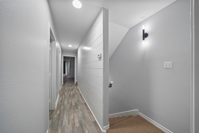 hallway featuring wood-type flooring and lofted ceiling