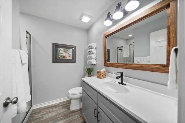 bathroom with walk in shower, vanity, toilet, and wood-type flooring