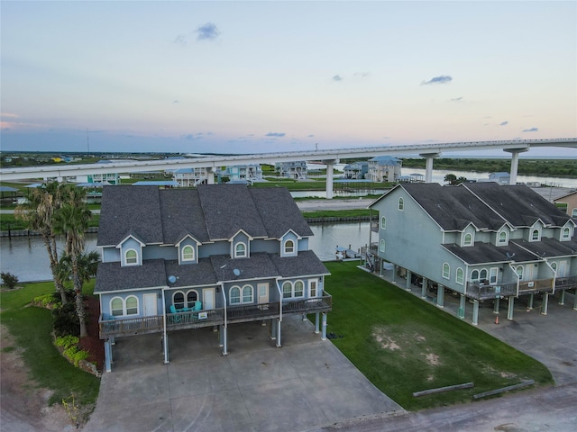 aerial view at dusk featuring a water view