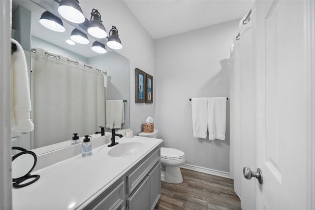 bathroom with vanity, hardwood / wood-style flooring, and toilet