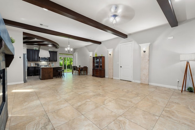 unfurnished living room with ceiling fan with notable chandelier and beamed ceiling