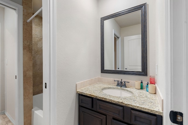 bathroom with tiled shower / bath and vanity