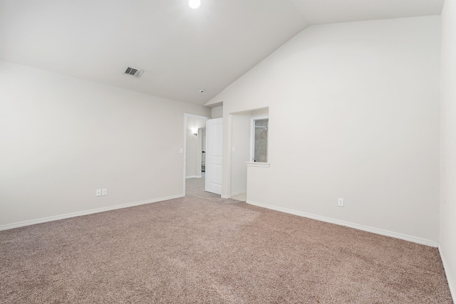 carpeted empty room with vaulted ceiling