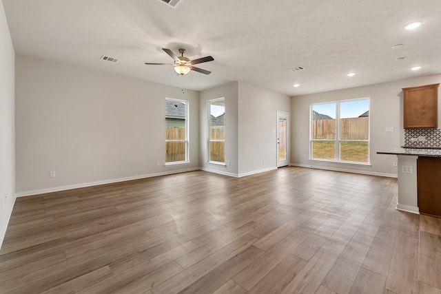 unfurnished living room with ceiling fan and light wood-type flooring