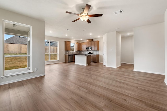 unfurnished living room featuring ceiling fan and light wood-type flooring