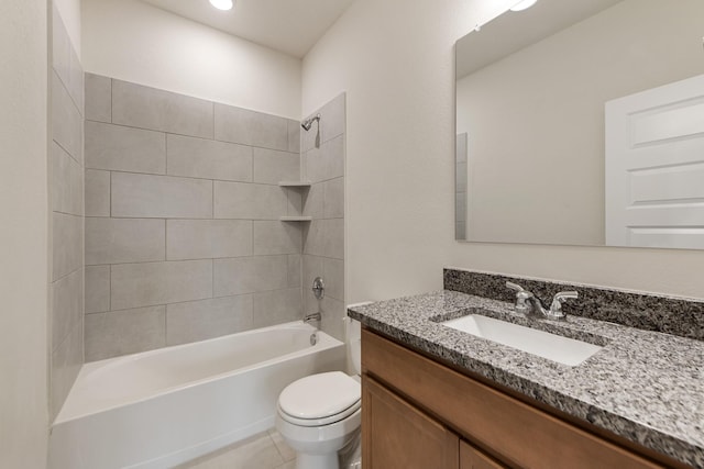 full bathroom featuring tiled shower / bath, vanity, toilet, and tile patterned flooring