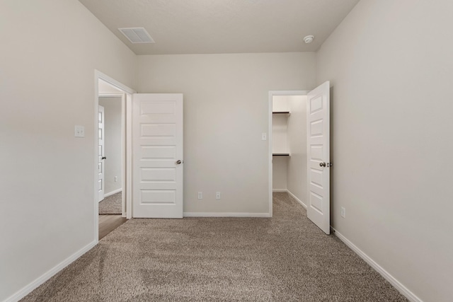 unfurnished bedroom featuring carpet and a spacious closet