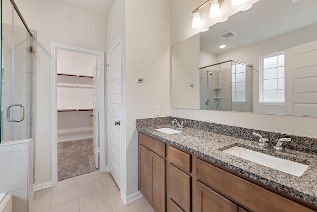 bathroom featuring tile patterned flooring, vanity, and a shower with door