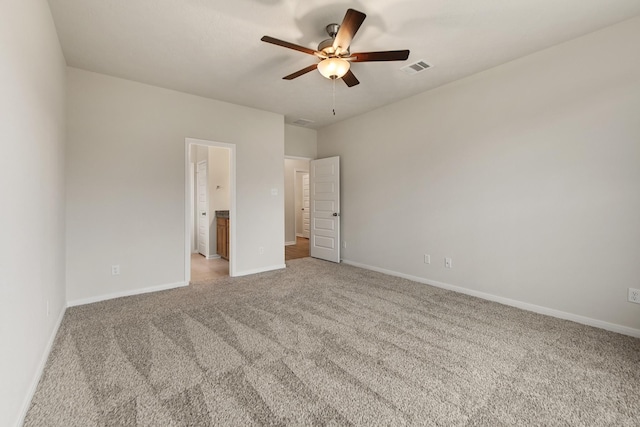 unfurnished bedroom with ceiling fan, connected bathroom, and carpet