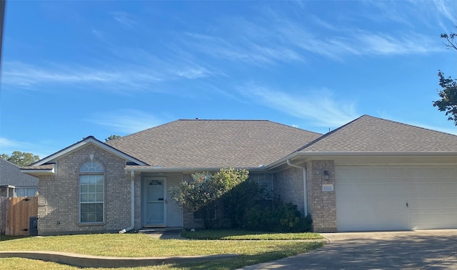 single story home featuring a garage and a front lawn