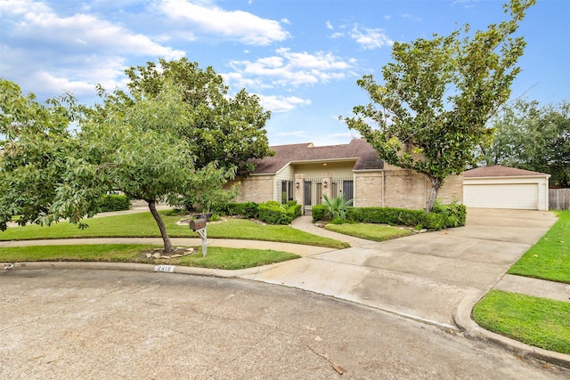 view of front of home featuring a detached garage and a front lawn