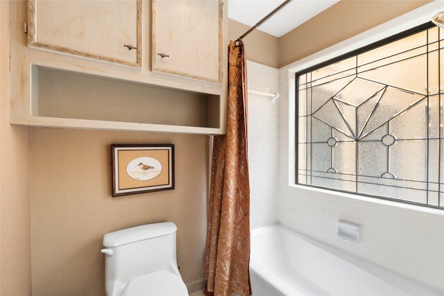 bathroom featuring shower / bathtub combination with curtain and toilet