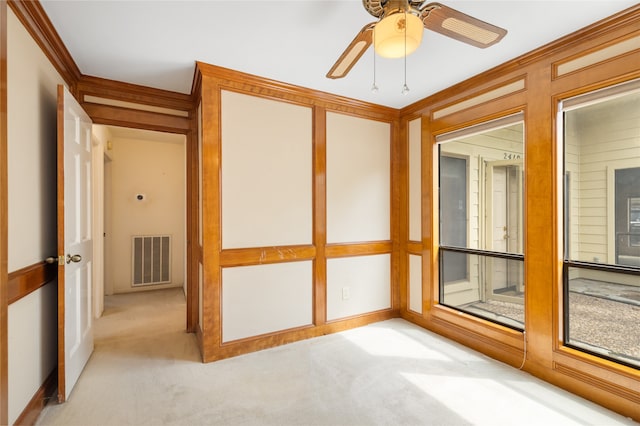 carpeted spare room featuring ornamental molding and ceiling fan