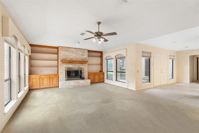 unfurnished living room featuring light carpet, ceiling fan, and a fireplace