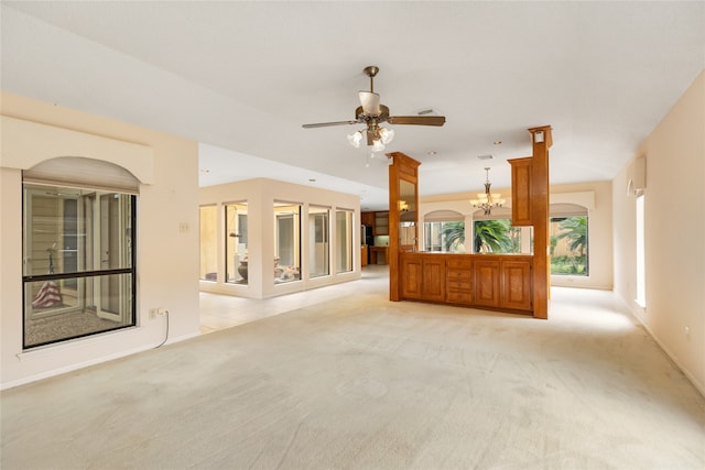 unfurnished living room with ceiling fan with notable chandelier and light colored carpet