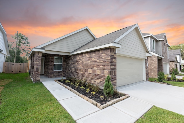 ranch-style home featuring a garage and a lawn