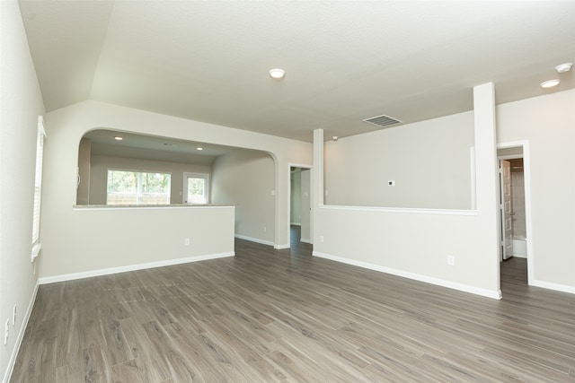 unfurnished room featuring vaulted ceiling, a textured ceiling, and dark hardwood / wood-style floors