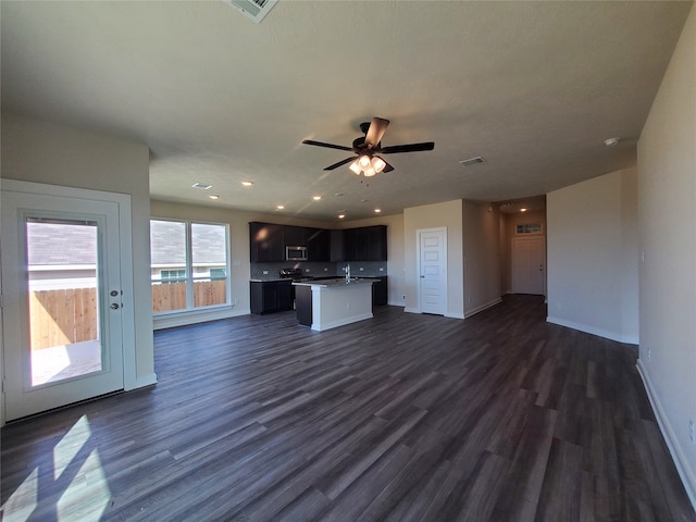 unfurnished living room with ceiling fan, dark hardwood / wood-style flooring, and sink