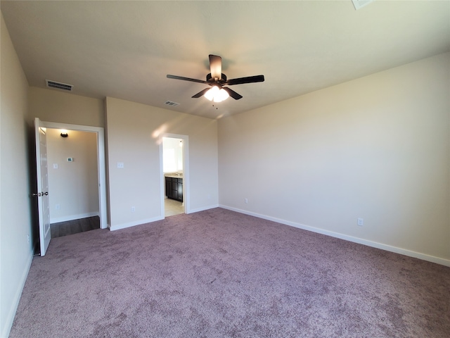 unfurnished bedroom with carpet flooring, ceiling fan, and ensuite bathroom