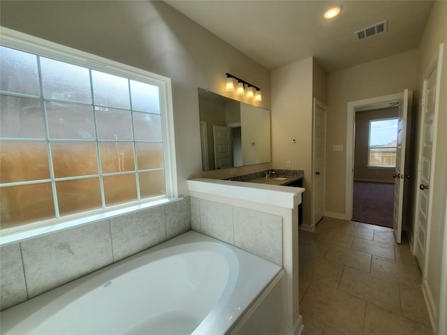 bathroom featuring tile patterned floors, a bathing tub, and vanity