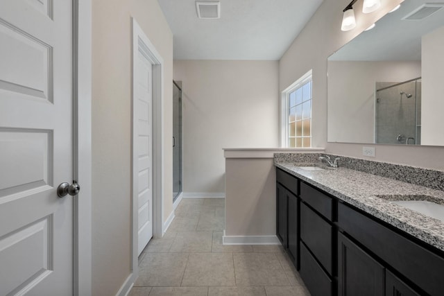 bathroom with a sink, a stall shower, baseboards, tile patterned flooring, and visible vents