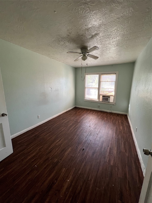 spare room with a textured ceiling, cooling unit, dark hardwood / wood-style flooring, and ceiling fan