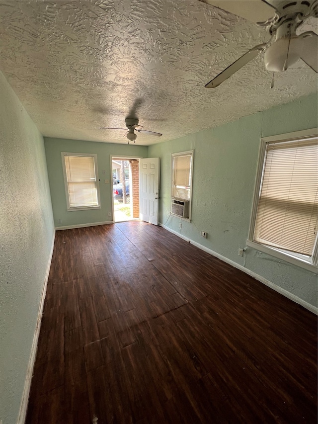 unfurnished living room featuring wood-type flooring, cooling unit, ceiling fan, and a textured ceiling