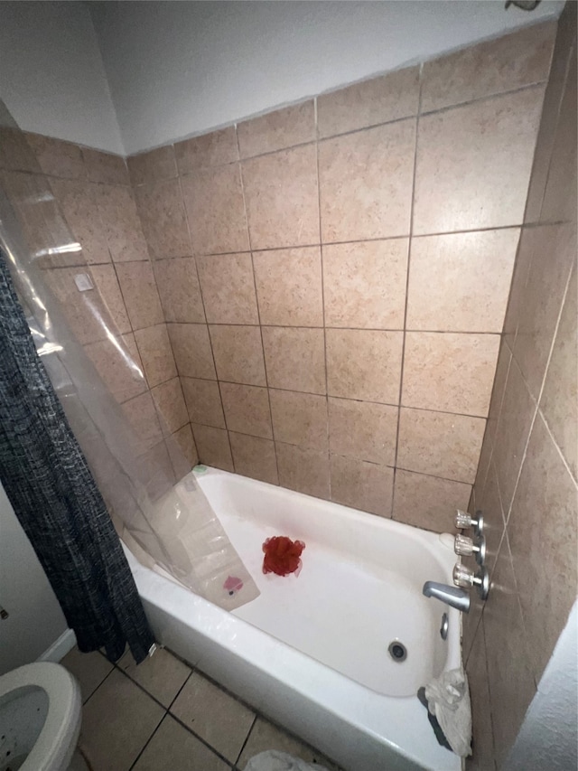 bathroom with tile patterned flooring, shower / tub combo, and toilet