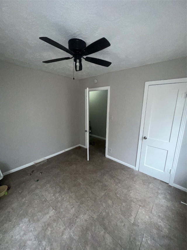 unfurnished bedroom featuring ceiling fan and a textured ceiling