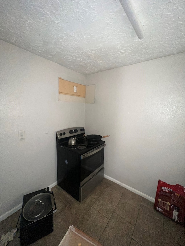 interior space with a textured ceiling and dark tile patterned floors