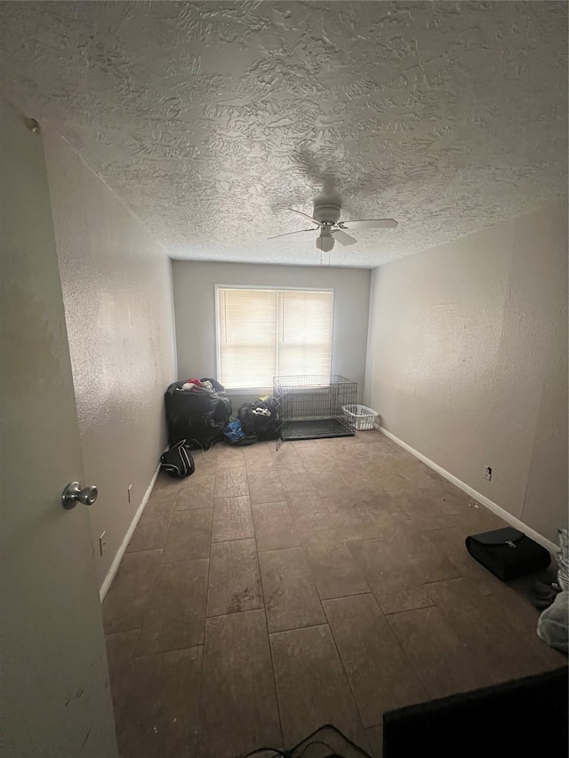 empty room featuring ceiling fan and a textured ceiling