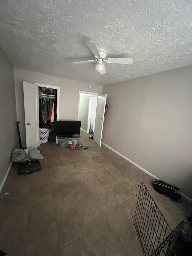 bedroom featuring a closet, ceiling fan, and a textured ceiling