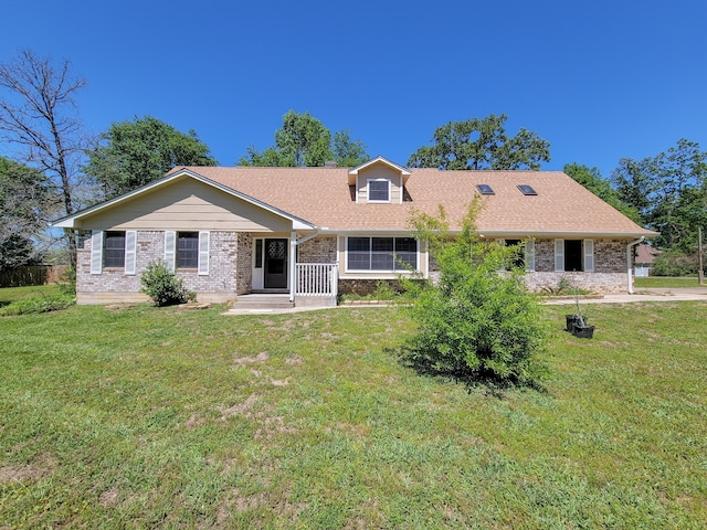 ranch-style home with a front lawn, a shingled roof, and brick siding