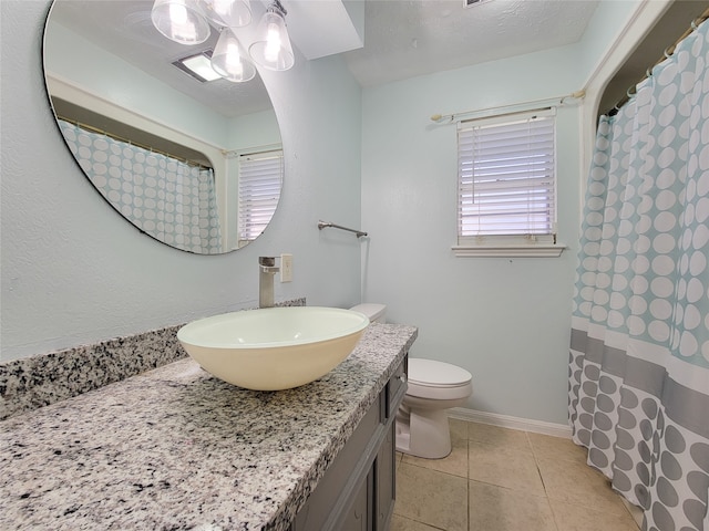 bathroom featuring a textured ceiling, vanity, toilet, and tile patterned floors