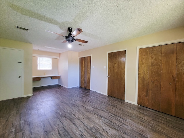 interior space with ceiling fan, a textured ceiling, and dark wood-type flooring