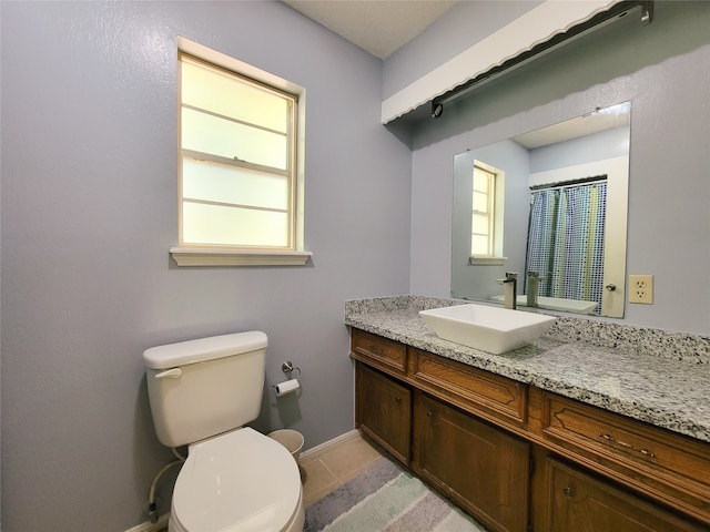 bathroom with plenty of natural light, vanity, and toilet