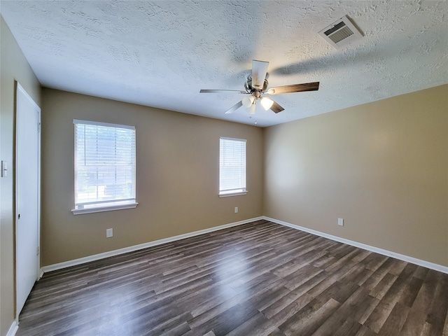 spare room featuring ceiling fan, dark wood-type flooring, and a textured ceiling