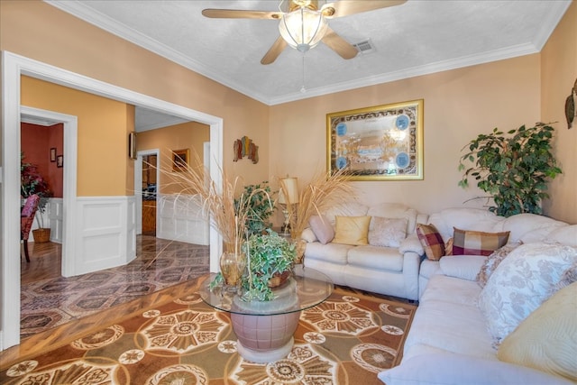 living room with wood-type flooring, ceiling fan, and crown molding