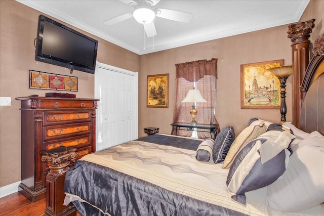 bedroom featuring hardwood / wood-style flooring, ornamental molding, ceiling fan, and a closet