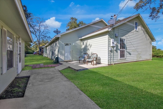 rear view of house with a patio and a lawn