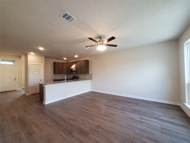 kitchen featuring dark hardwood / wood-style floors, dark brown cabinets, and kitchen peninsula