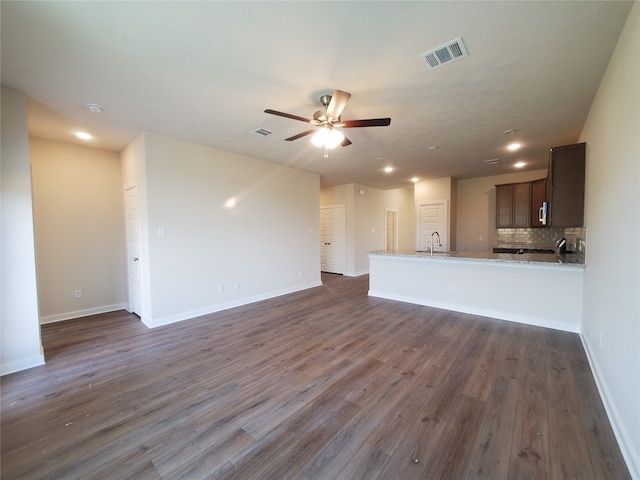 unfurnished living room with ceiling fan, sink, and dark hardwood / wood-style floors