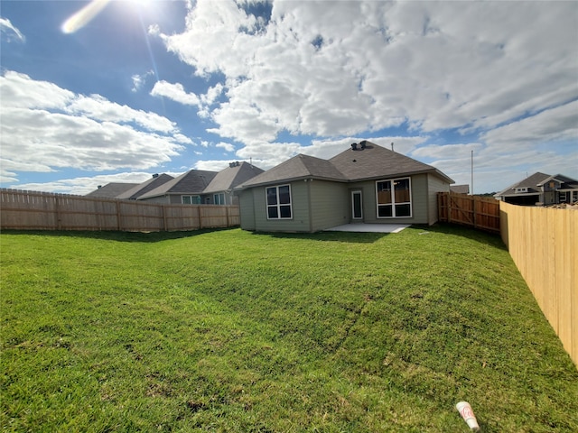 rear view of property with a yard and a patio