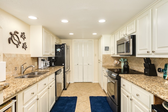 kitchen with white cabinets, stainless steel appliances, backsplash, and sink