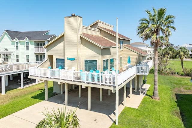 back of property with a yard, a carport, and a wooden deck