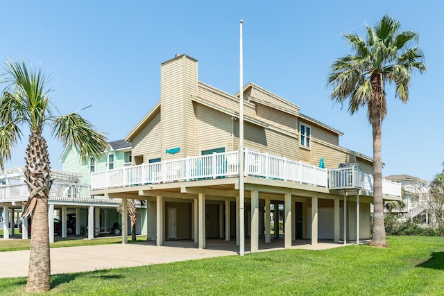 rear view of house with a deck and a yard