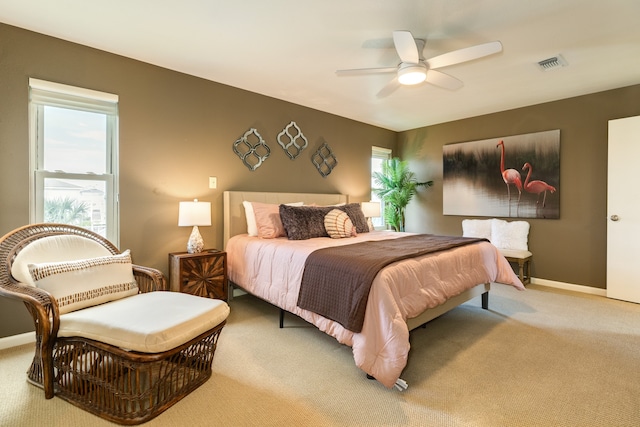 carpeted bedroom with multiple windows and ceiling fan