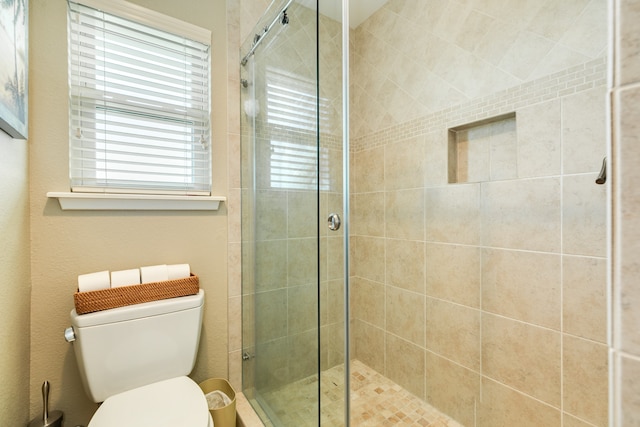 bathroom featuring walk in shower and toilet