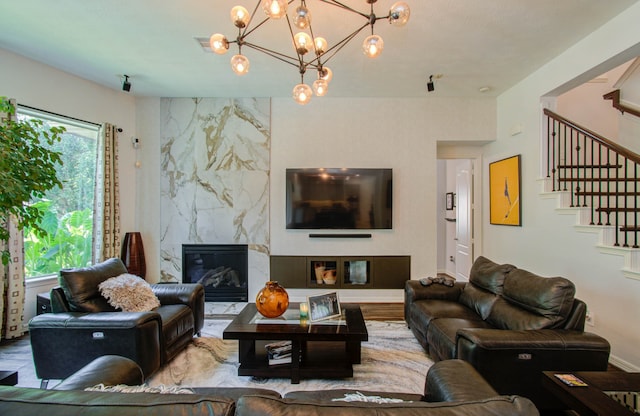 living room with a high end fireplace, wood-type flooring, and a chandelier